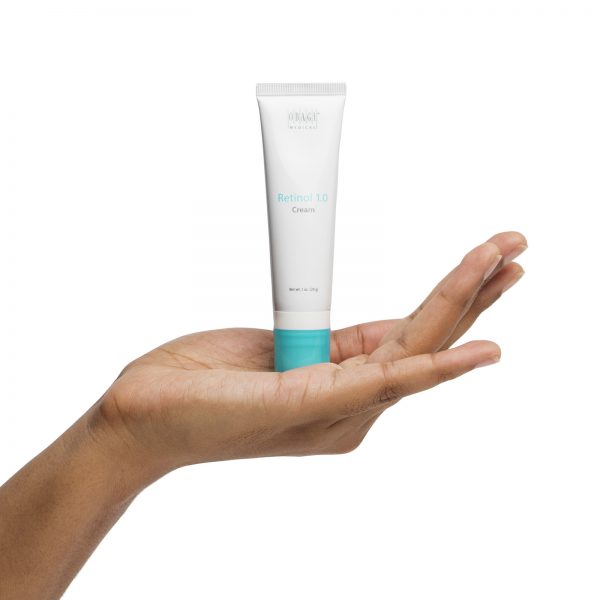 A person holding up their hand with an empty tube of lotion.